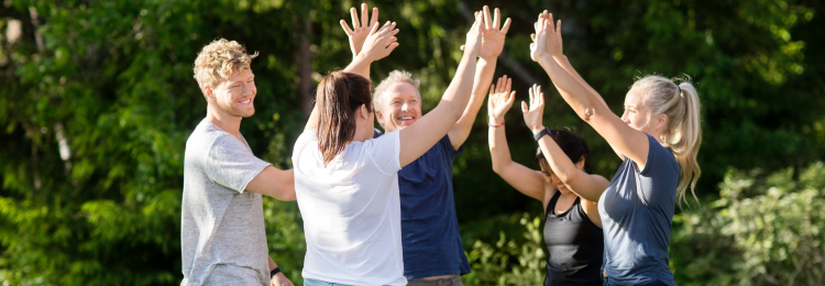 a group of friends high fiving after winning an outdoor game