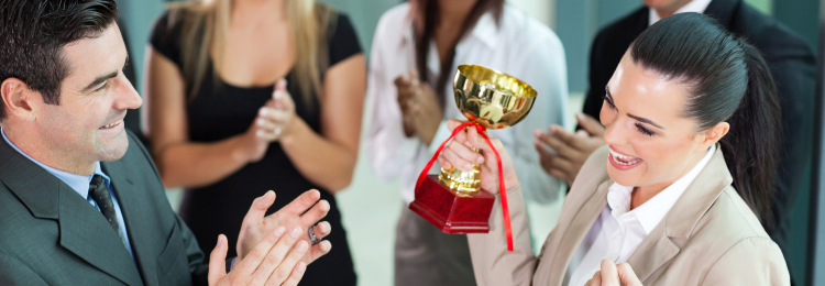 Young woman winning a trophy at her job